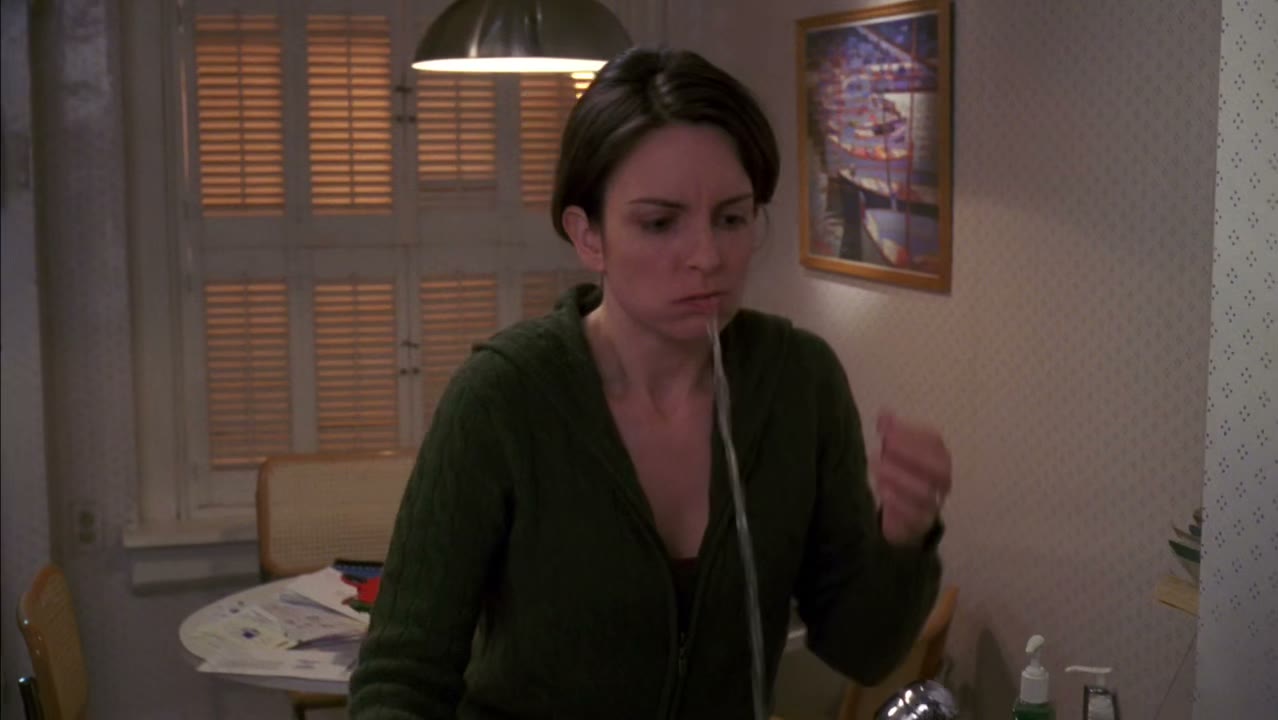 [TV playing in background]